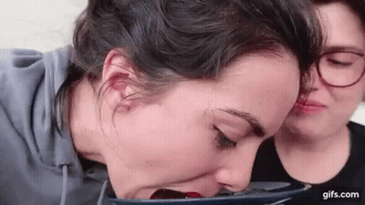 Two Women Sitting One Drinking From Cup GIF