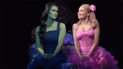 Two Women Sitting Together On Stage GIF