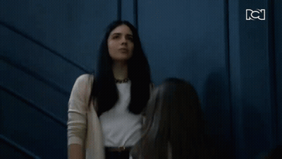 Two Women Standing And Looking At Each Other GIF