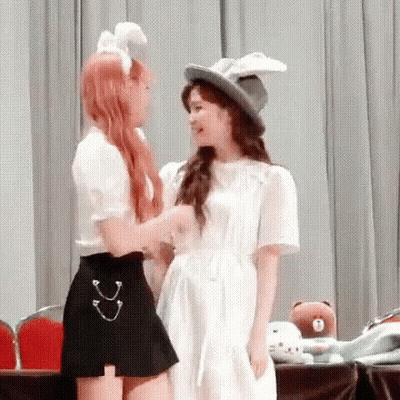 Two Women Standing And Looking At Each Other GIF