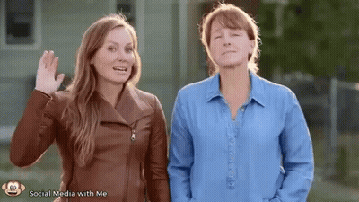 Two Women Standing And Waving GIF