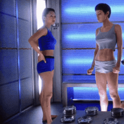 Two Women Standing In Blue Lit Room GIF