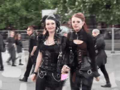 Two Women Standing In Crowd GIF