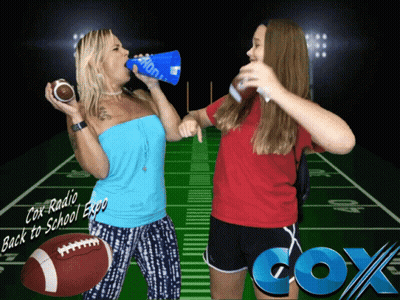Two Women Standing In Front Of A Football Field With Cox Radio Written On The Bottom GIF