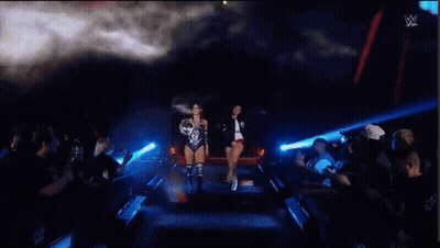 Two Women Standing In Front Of A Sign That Says Evolve Womens Champion Kendal Grey GIF