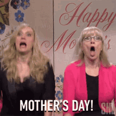 Two Women Standing in Front of Happy Mothers Day Sign