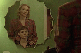 Two Women Standing In Front Of Mirror GIF