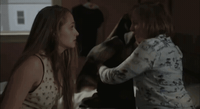Two Women Standing In Room Looking At Each Other GIF