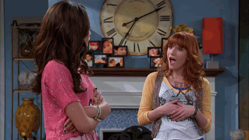 Two Women Standing Next To Each Other In Front Of A Clock That Says ' The Williams ' GIF