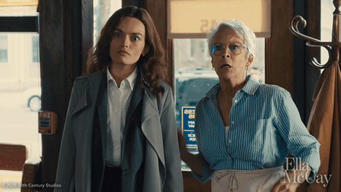 Two Women Standing Next To Each Other In Front Of A Sign That Says " Fire " GIF