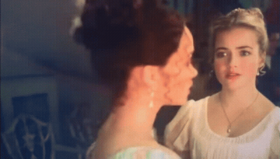 Two Women Standing Next To Each Other Looking At Each Other GIF