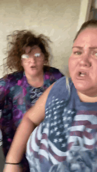 Two Women Standing Next To Each Other One In American Flag Shirt GIF
