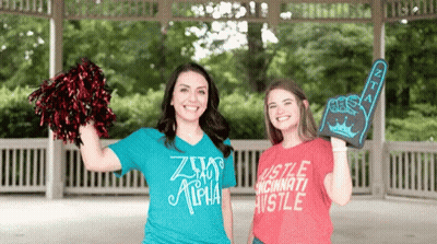 Two Women Standing Next To Each Other One Wearing A Shirt That Says Hustle Cincinnati Hustle GIF