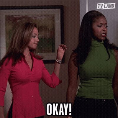 Two Women Standing Next To Each Other Saying Okay GIF