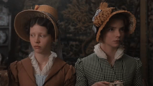Two Women Standing Next To Each Other Wearing Hats And Dresses GIF