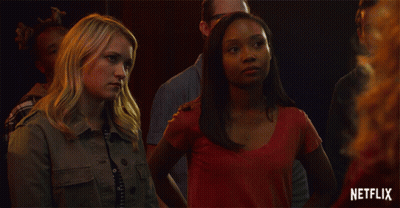 Two Women Standing Next To Each Other With A Netflix Logo In The Background GIF