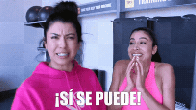Two Women Standing Next To Each Other With A Sign That Says Trx In The Background GIF