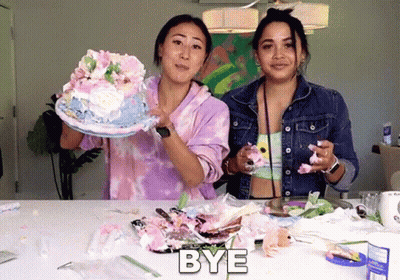 Two Women Standing Next To Each Other With One Holding A Cake And The Other Holding A Piece Of Cake With The Word Bye Ab GIF