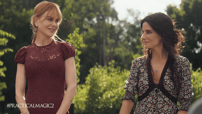 Two Women Standing Next To Each Other With #Practicalmagic2 On The Bottom Right GIF
