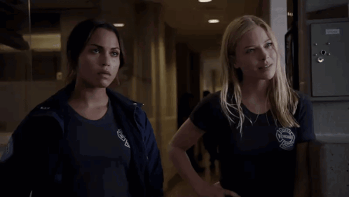 Two Women Standing Next To Each Other With Rescue Shirt GIF