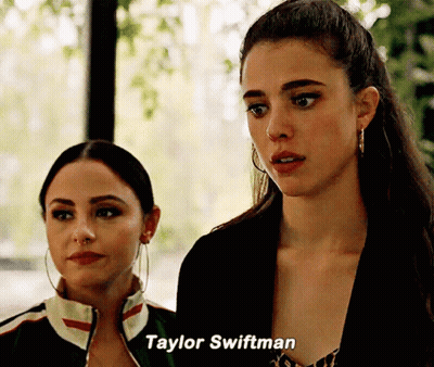 Two Women Standing Next To Each Other With Taylor Swiftman Written On The Bottom GIF