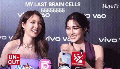 Two Women Standing Next To Each Other With The Words My Last Brain Cells Written On The Wall Behind Them GIF