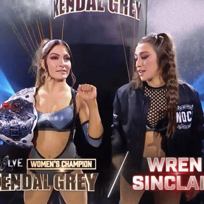 Two Women Standing Next To Each Other With The Words Women 'S Champion Kendal Grey And Wren Sinclair Below Them GIF