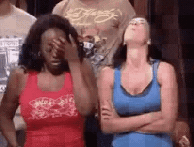 Two Women Standing With Arms Crossed One Covering Face GIF