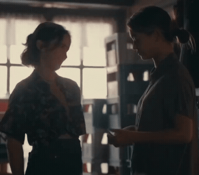 Two Women Talking In Dark Room GIF