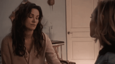 Two Women Talking In Room With Door GIF
