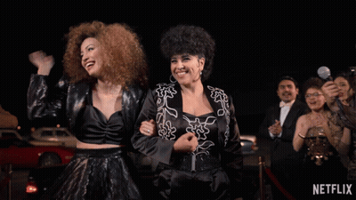 Two Women Walking Down Red Carpet With Netflix Logo GIF