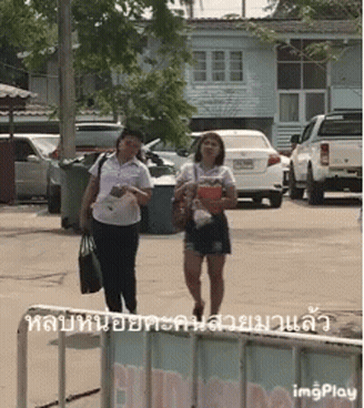 Two Women Walking Down Street GIF