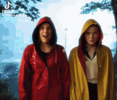 Two Women Wearing Red And Yellow Raincoats Are Standing Next To Each Other GIF