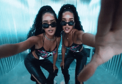 Two Women Wearing Sunglasses Are Taking A Selfie Together . GIF