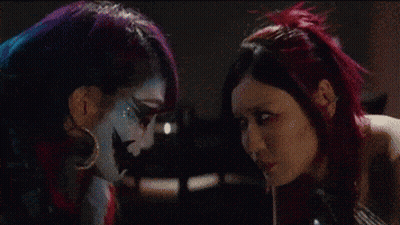 Two Women With Faces Painted Different Colors GIF