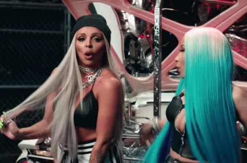 Two Women With Long Hair Are Standing Next To Each Other And One Has A Beanie On GIF