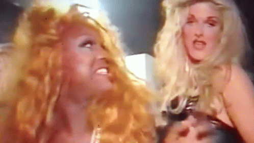 Two Women With Long Red Hair Are Standing Next To Each Other And Making Funny Faces . GIF