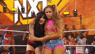 Two Women Wrestling In A Ring With A Sign That Says Lola Vice On It GIF