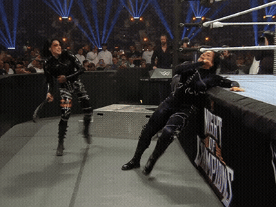 two women wrestling in a ring with a sign that says night of champions on it