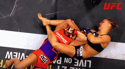 Two Women Wrestling In Front Of Live Sign GIF