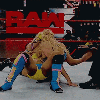 Two Women Wrestling In Ring With Raw Sign GIF