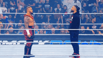 Two Wrestlers Are Facing Each Other In A Wrestling Ring With A Crowd Watching GIF