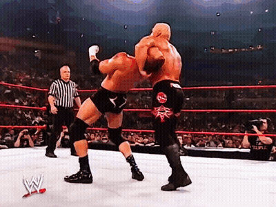 Two Wrestlers Are Fighting In A Ring With A Referee In The Background GIF