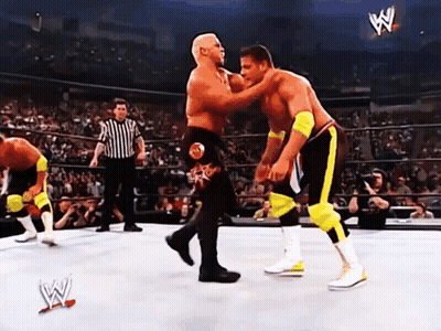 Two Wrestlers Are Fighting In A Wrestling Ring With A Referee In The Background And A Sign That Says W On It GIF