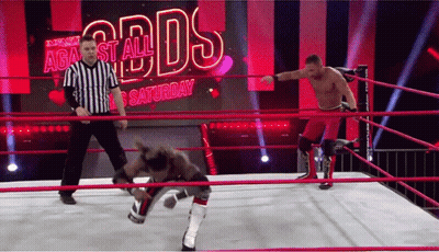 Two Wrestlers Are In A Ring With A Referee In Front Of A Screen That Says Against All Odds Saturday GIF