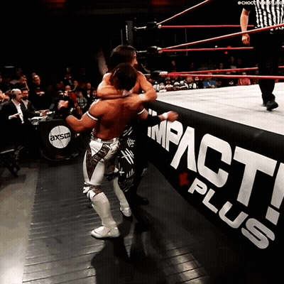 Two Wrestlers Are In A Wrestling Ring With A Sign That Says Impact Plus GIF