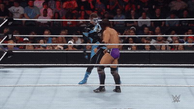 Two Wrestlers Are In A Wrestling Ring With A W Logo In The Background GIF