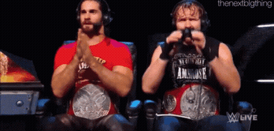 Two Wrestlers Are Sitting Next To Each Other With Their Hands Folded . GIF