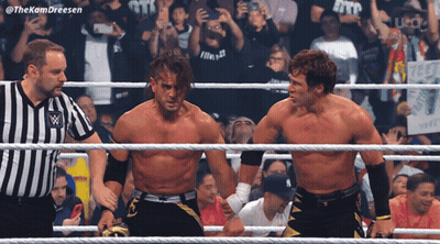 Two Wrestlers Are Standing In A Ring With A Referee And A Crowd Behind Them With The Hashtag #Thekamdreesen GIF