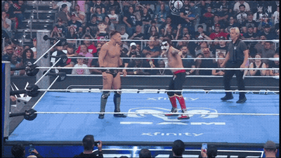 Two Wrestlers Are Standing In A Ring With Xfinity Written On The Floor GIF